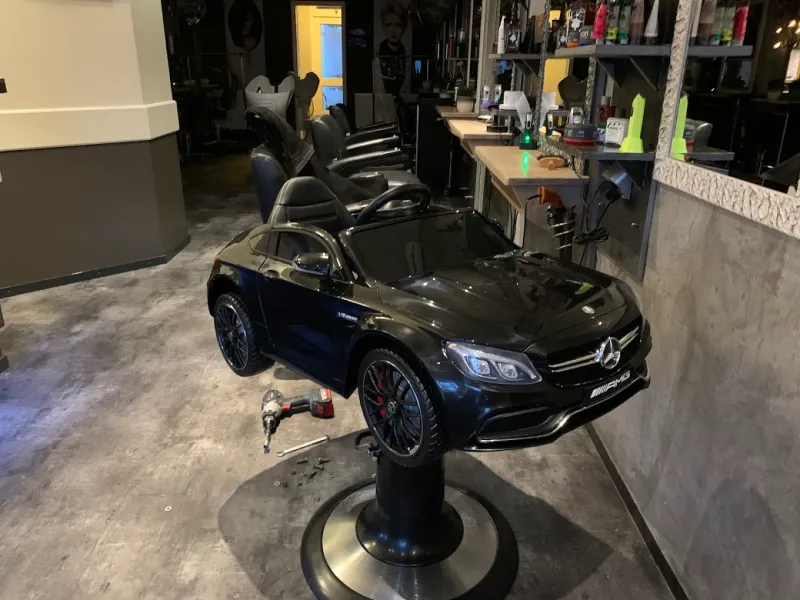 De kindersalonstoel in de vorm van een Mercedes 63 AMG